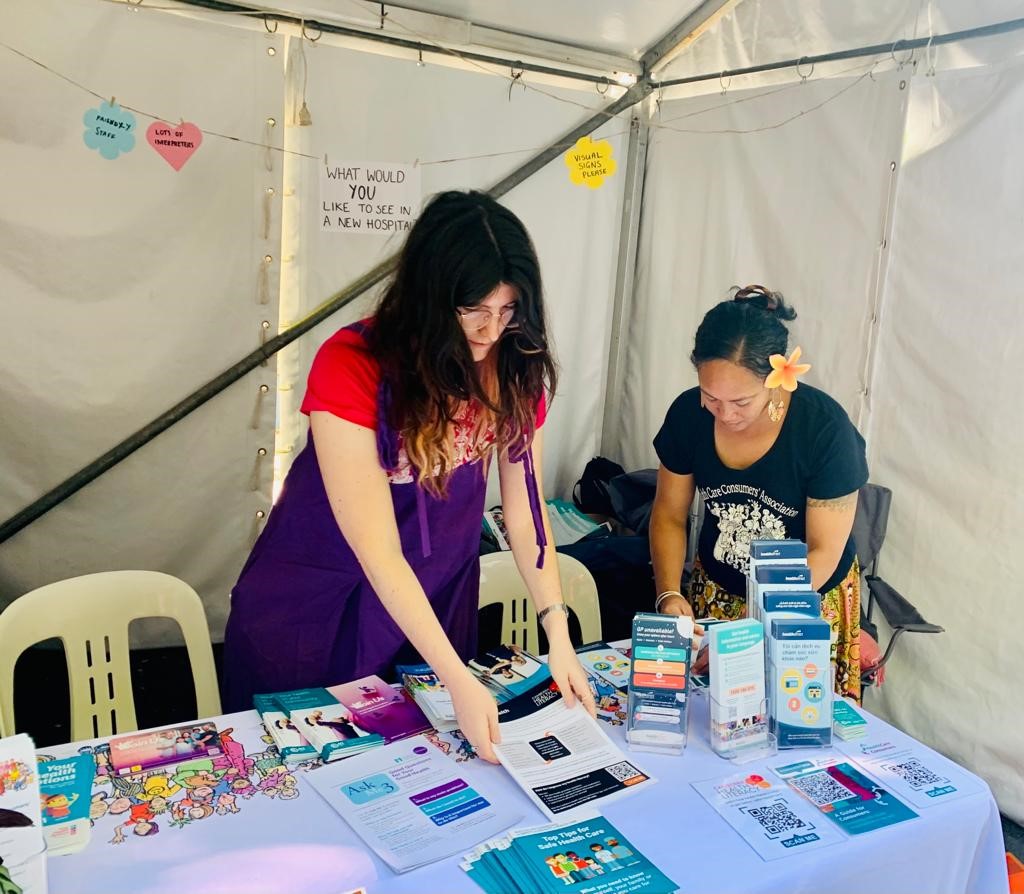 Our staff members Darcy and Pene are setting out stacks of paper resources on the table in our stall.